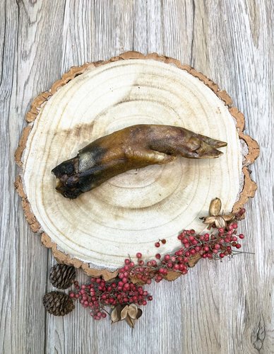 a boar foot dog treat on a wooden plate